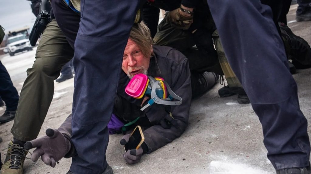 وجد المصوّر الصحفي جون أبرناثي نفسه ممدّدًا على الأرض، محاطًا بعشرات العناصر الفدرالية